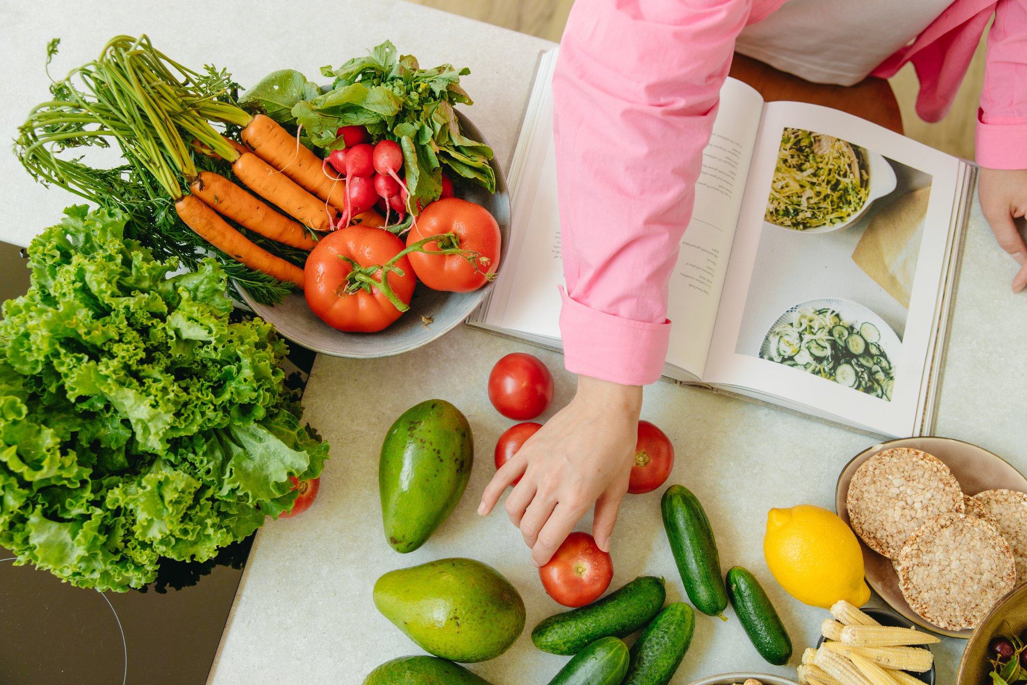 Person in Pink Long Sleeve Shirt Holding Green Vegetable